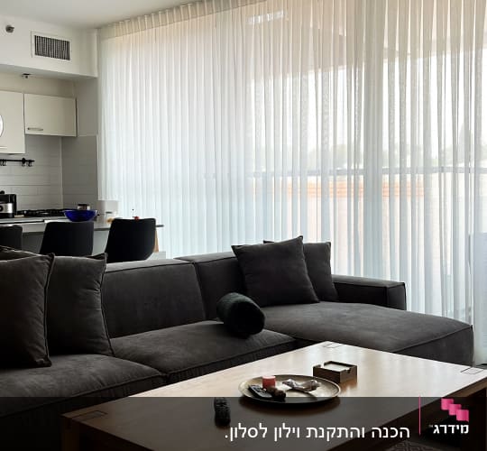 וילון לבן שקוף תלוי על חלון גדול